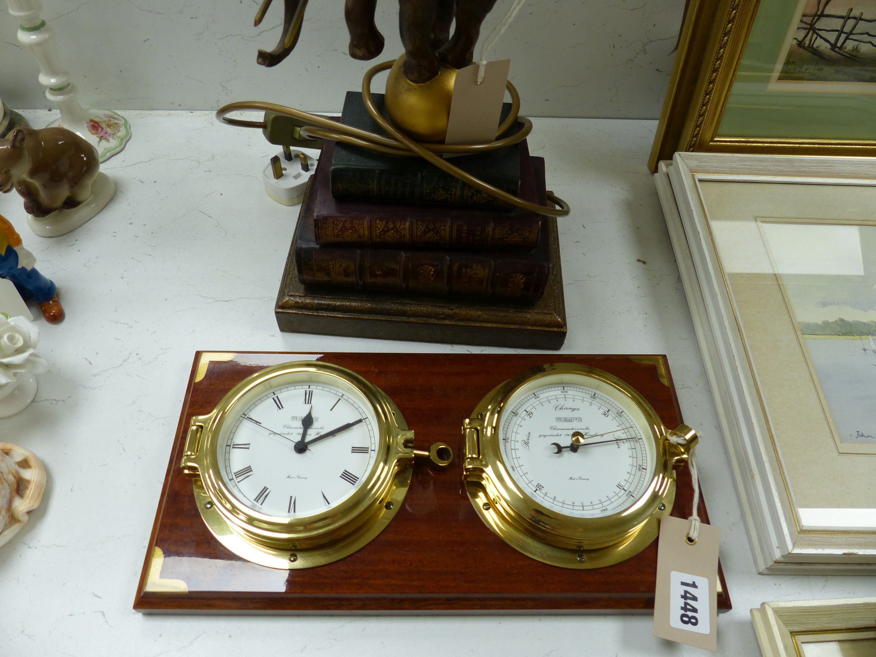 A Wempe wall-mounted ship's style clock/barometer and an 'elephant on books' table lamp